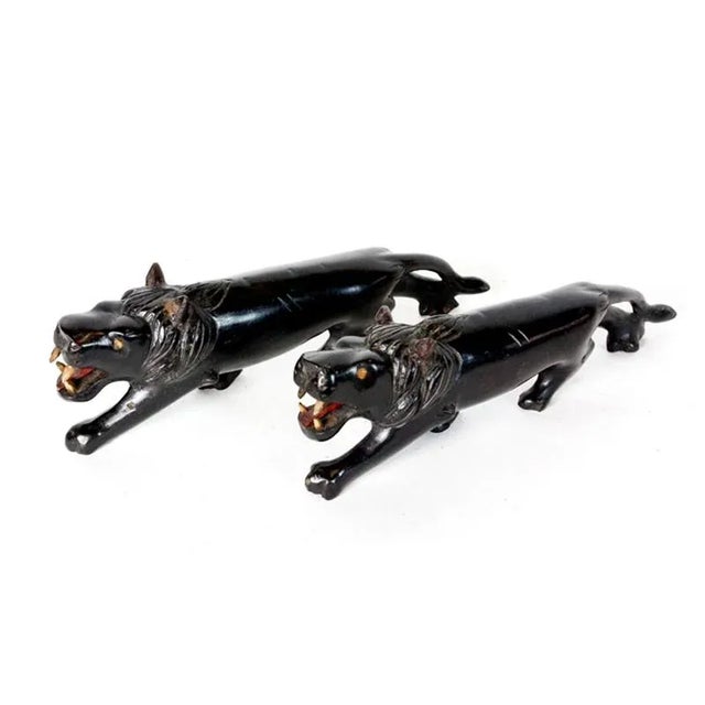 A pair of Anglo Indian carved ebony lions, with intricate carved teeth and eye details. Larger: Height: 3.5, Width: 10.25,...