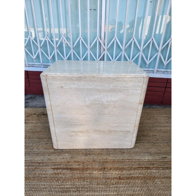 Elegant travertine stone base table with a post-modern monolithic design. This piece is crafted from natural stone with a...