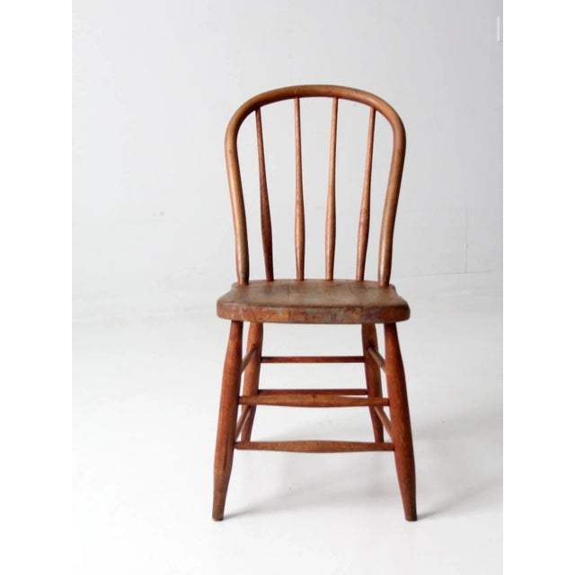 This is an antique bow back Winsdor chair. The classic farmhouse dining chair has a round spindle back. Beautiful patina...