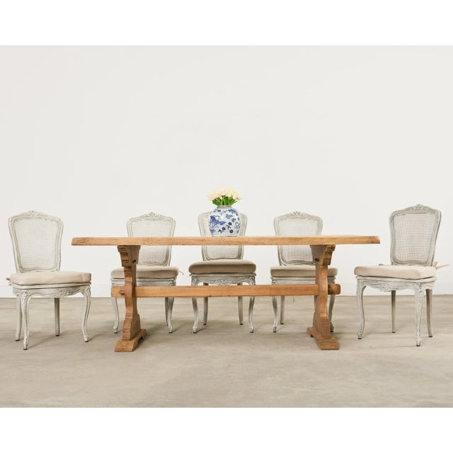 Rustic 20th century country French provincial style farmhouse dining table featuring a bleached oak finish. The table has...