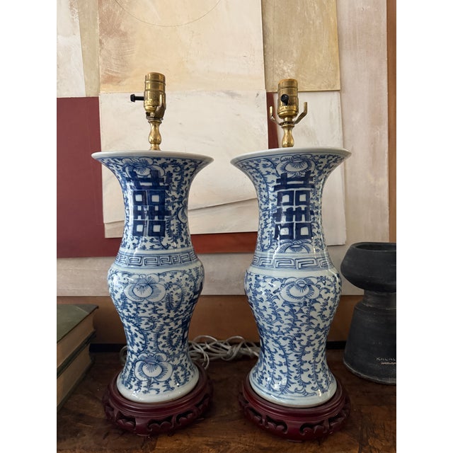 A striking pair of vintage blue and white porcelain table lamps featuring the traditional Double Happiness symbol on each...