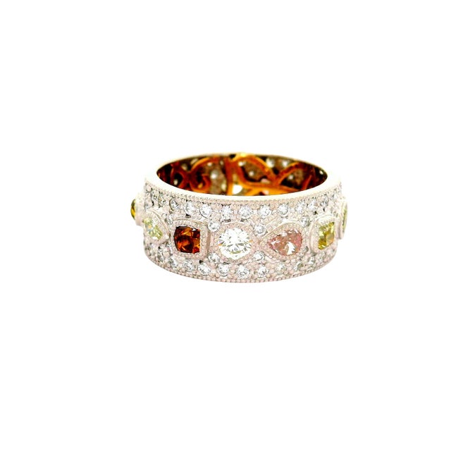 A striking and contemporary band ring. This piece showcases a captivating array of multi-colored diamonds, totaling 2.48...