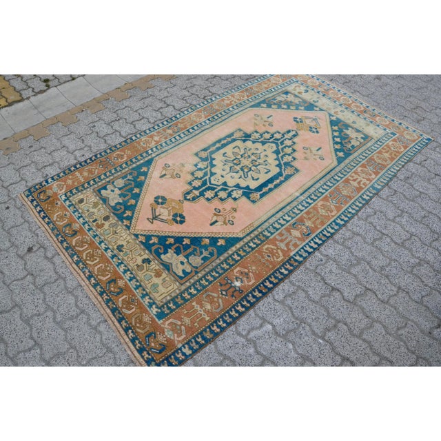 This is a vintage Turkish Oushak rug from the 1960s. The piece was hand-knotted.