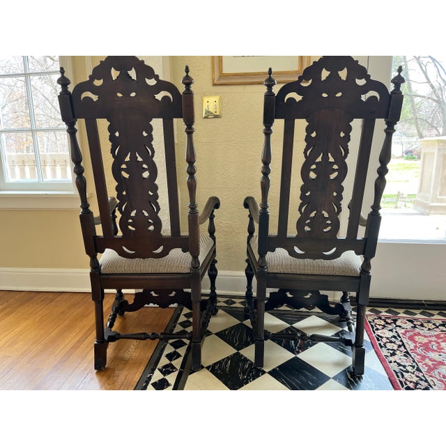 An extraordinary pair of Restoration style, hand carved fruitwood arm chairs having hand turned spindle uprights, with an...