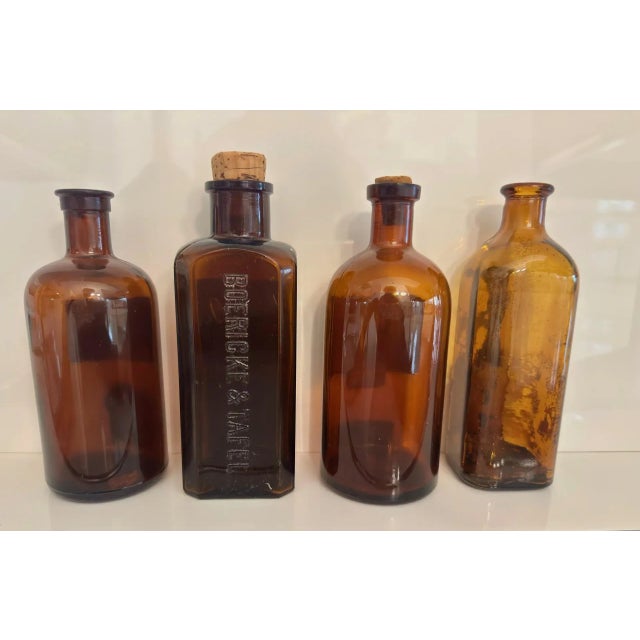 This is a fine set of four antique, deep amber-brown glass bottles, which were used for pharmaceutical and chemical...