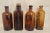 This is a fine set of four antique, deep amber-brown glass bottles, which were used for pharmaceutical and chemical...