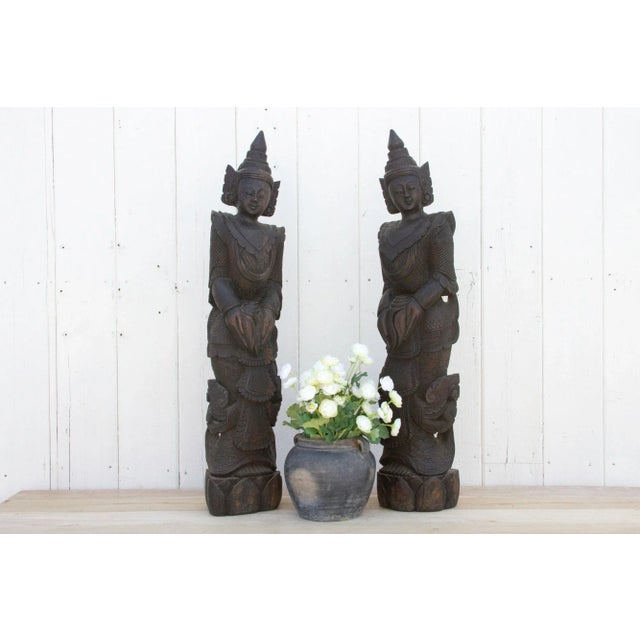 Experience the mystique of the East with this stunning pair of antique carved wood Asian figures, possibly from Bali....