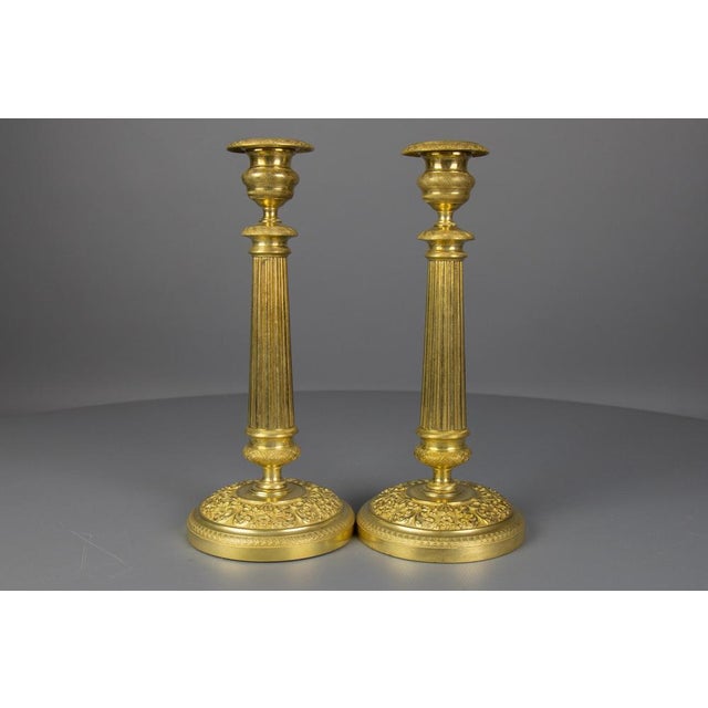 A beautiful pair of antique French Restauration style brass candlesticks with removable bobeches (drip trays) from ca....