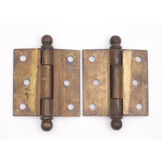 Vintage cabinet hinges made of brass plated steel with ball tips, three knuckles, and a template hole pattern. The...