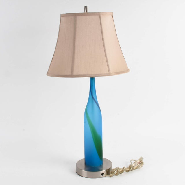 This Modern Abstract Blue Table Lamp is a striking blend of artistic expression and functional lighting. The lamp features...