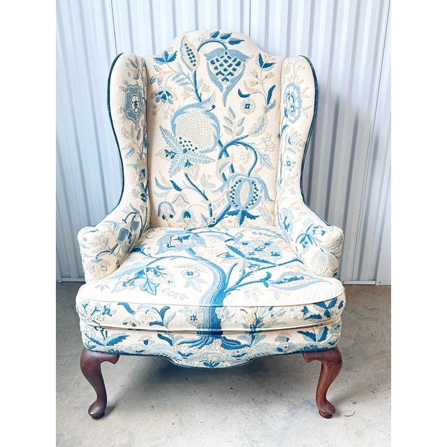 Fabulous vintage wingback chair. Features crewel embroidery in a floral pattern. Blues and off white. Velvet back. Made by...