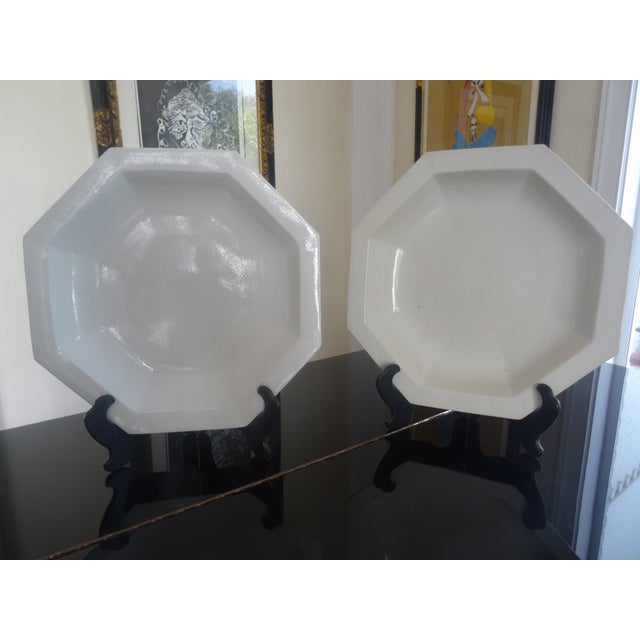 A surpurb pair of large chargers with black lacquered stands attributed to the reproduction porcelain line of Dennis and...