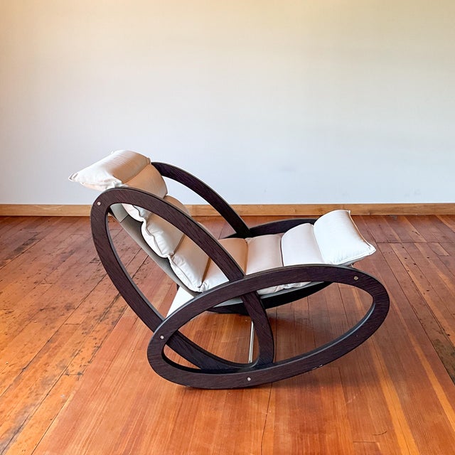Dark wood rocking chair with white leather removable cushion. This chair is a sleek mid century modern design attributed...