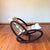 Dark wood rocking chair with white leather removable cushion. This chair is a sleek mid century modern design attributed...