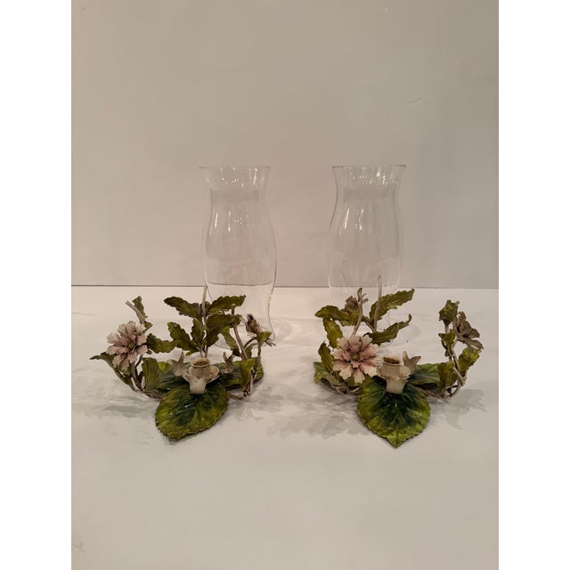 Lovely pair of hand painted tole candle hurricanes having glass tops and pastel weathered patina.