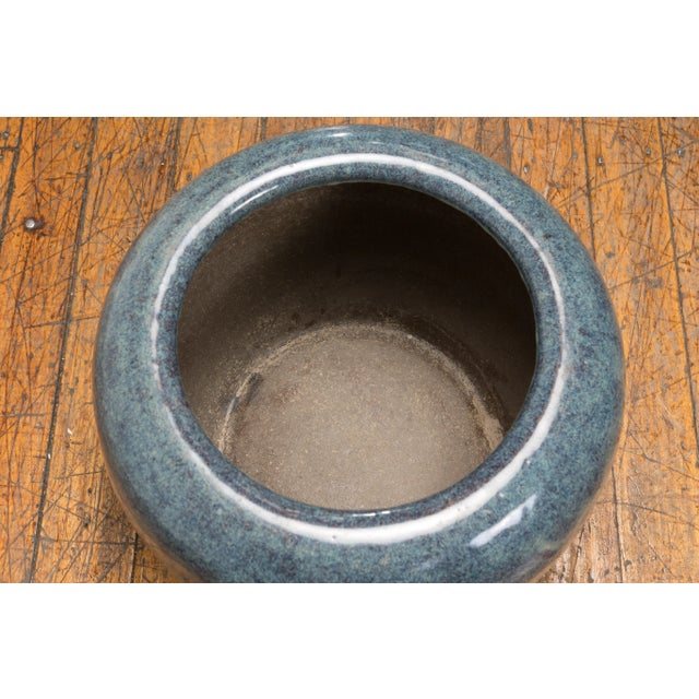 A vintage Chinese blue ceramic planter from the mid 20th century with wave effects and tapering lines. Emanating the...