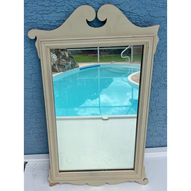 This vintage, cream-colored wall mirror features an arched, shabby chic design. Solid wood.