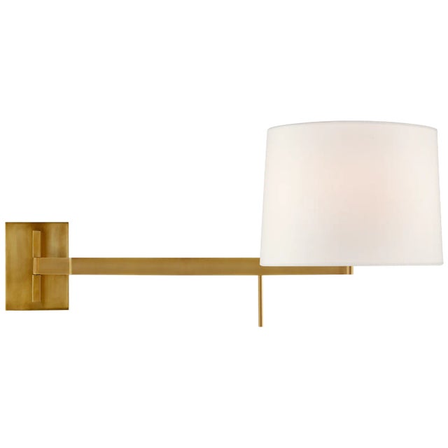 Sweep Medium Left Articulating Sconce in Soft Brass with Linen Shade Designer: Barbara Barry Height: 13" Extension: 11.75"...