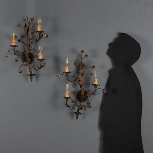 Pair of burnished metal wall lamps. Three lights supported by curved arms, embellished with leaf-shaped sheet metal work...