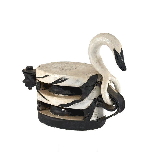 An early 20th-century double-sheave industrial pulley repurposed into a folk art object with a hand-painted swan detail....
