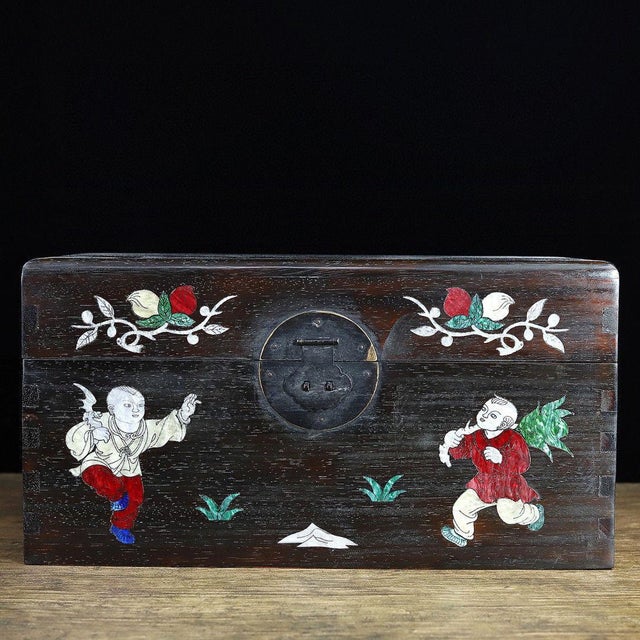 This decorative wooden chest features intricate hand-laid mother-of-pearl shell inlay across the lid and front panel. The...