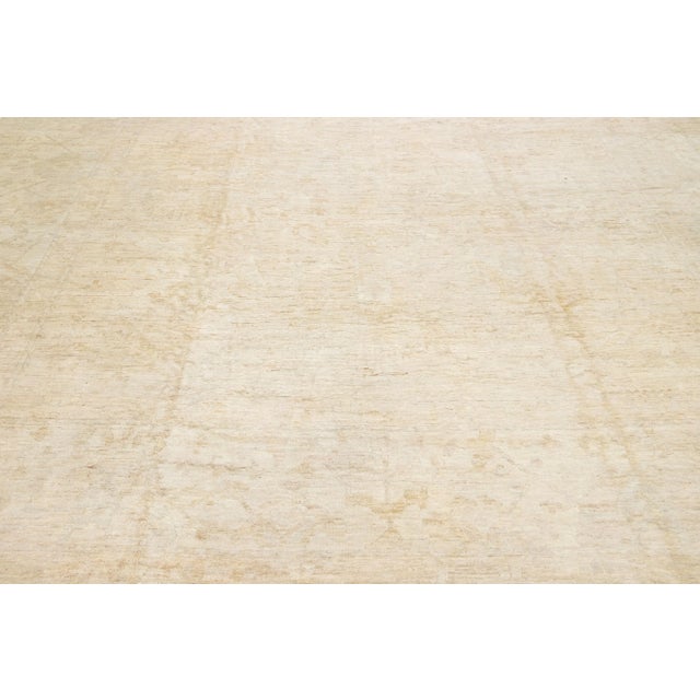 Beautiful contemporary Oushak hand-knotted wool rug with a beige field. This Oushak rug has a scattered light brown spray...