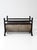 A vintage mid-century fireplace log holder combining a curved steel cradle with a dark iron frame, riveted construction,...