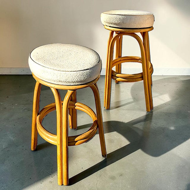 Restored pair of 1950s double-strand "Arched" Rattan bar stools with plush padded ivory toned upholstered seats. Each...