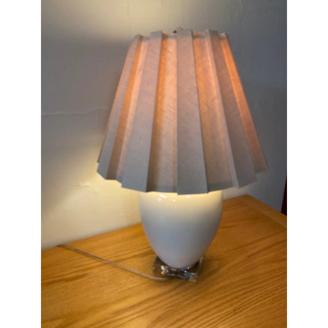 Smooth white ceramic table lamp with large pale pink ribbed pleated custom linen shade.