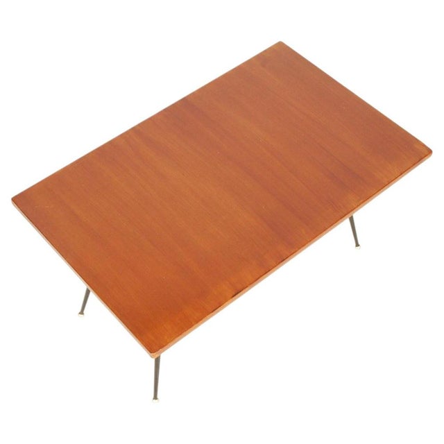 The table is distinguished by its essential rectangular wooden top and its elegant architectural base composed of four...