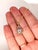 A white zircon glows with white brilliance at the heart of this round pendant, framed by a trail of brilliant natural...