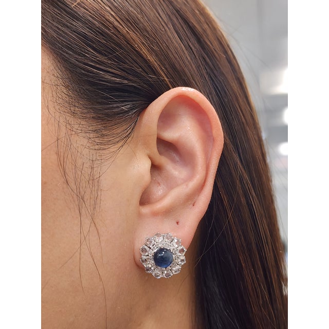 These Cabochon sapphire diamond earrings feature 56 diamonds weighing 3.32 ct and boast a color of F/G, and VS2/SI1 in...