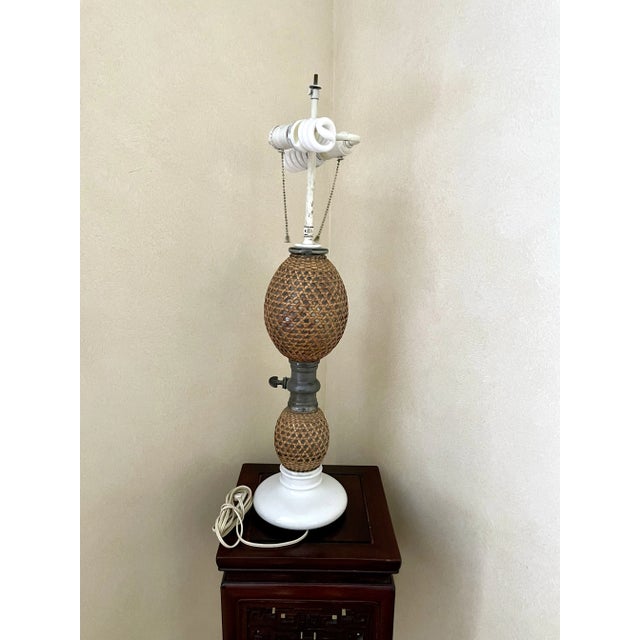 This lamp is so chic! An old glass seltzer bottle surrounded in rattan cane with original metal hardware and milk glass...