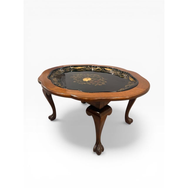 A charming chinoiserie-style coffee table featuring a removable hand-painted tray top, set within a scalloped wood frame....