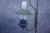 Antique wrought iron floor lamp in the Monterey style, featuring a lantern-form light with glass chimney and metal shade....