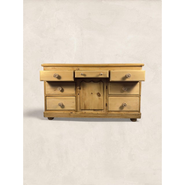 Antique English Pine Sideboard Seven drawers, a panelled cupboard, and bun feet, this late Victorian dresser base is the...