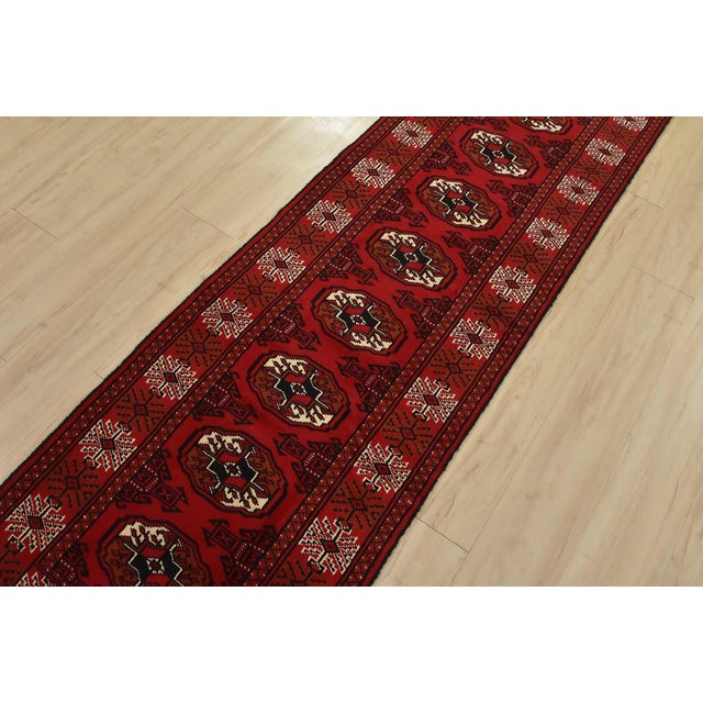 An authentic vintage tribal Turkmen runner, hand-knotted with fine wool and natural dyes. This nomadic rug features a row...