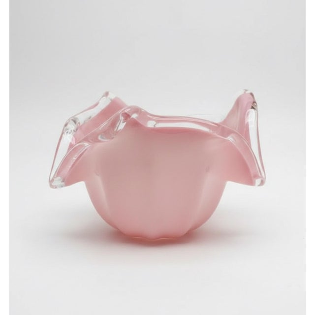 A striking vintage Italian art glass bowl featuring a soft pink body encased in substantial clear glass and formed into a...