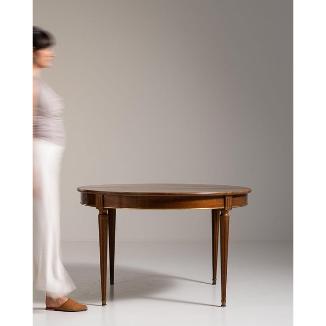 Oval walnut dining table in Rich Walnut Brown. Its rich walnut brown finish sets off tapered fluted legs, oval top, a...
