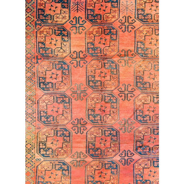 An early 20th century Afghani Bashir rug with multiple large octagonal medallions woven in indigo and gold, on an orange...