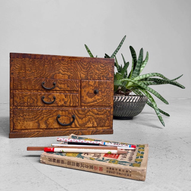 A refined Japanese haribako, or traditional sewing box, with richly figured wood, warm amber-brown tones and a practical...