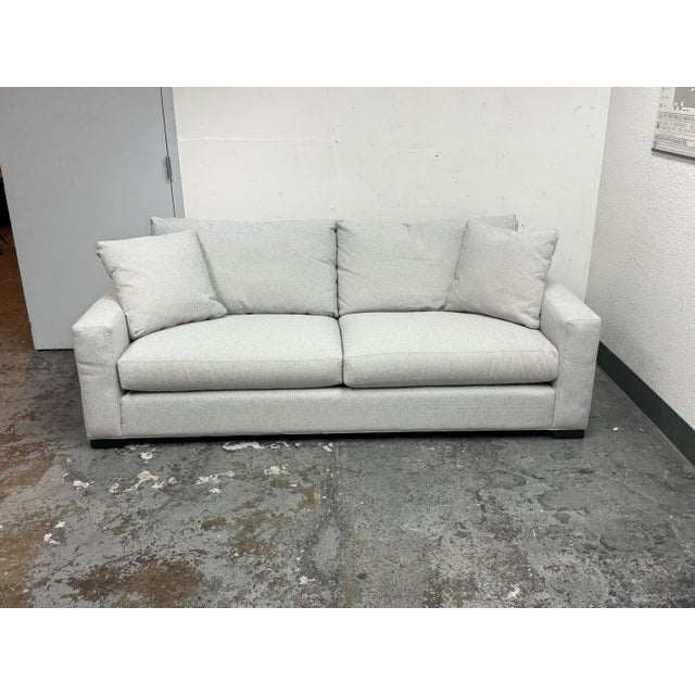 Design Plus Gallery presents the Metro Sofa from Room & Board. This sofa has light gray woven upholstery, squared track...