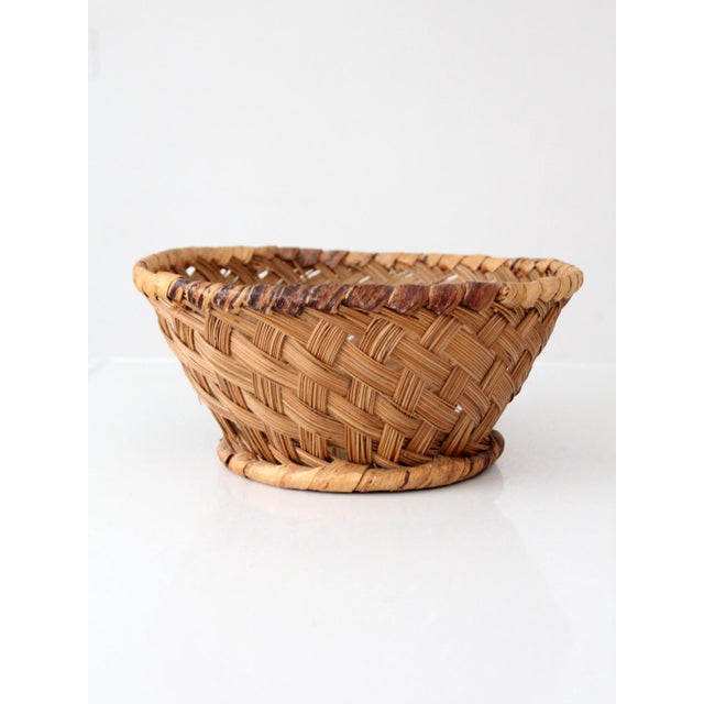 Beautiful vintage handwoven basket with a generous, rounded form, intricately patterned weave, wrapped rim, and raised...