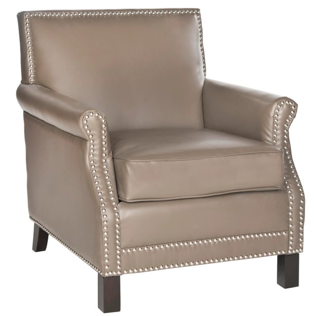 The distinguished chair, with slender frame, roll arms and silver nailhead details, is a fireside classic revved up with...