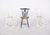 Three chairs with codtail backs. Painted wood, with cut-out backs and a hollowed-out ‘heart’ silhouette, evoking a...