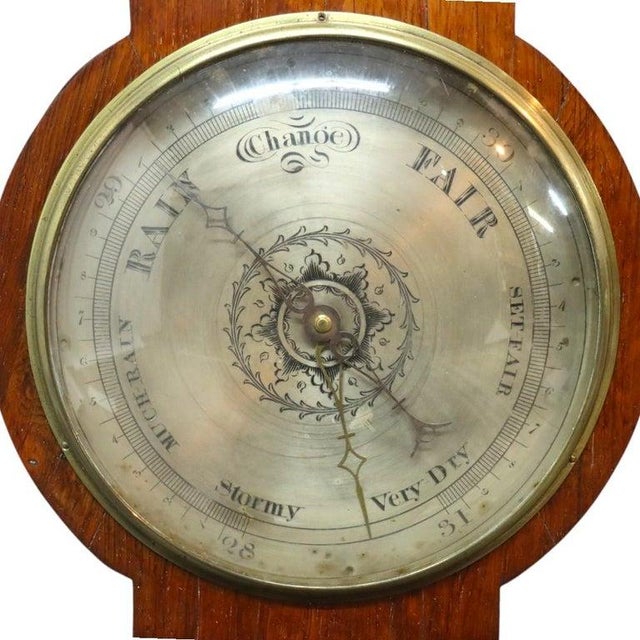 An antique English banjo barometer, dating to the late Victorian period, circa 1880. This scientific instrument is...
