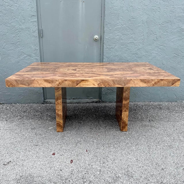 Striking vintage Postmodern dining table featuring a richly figured burlwood laminate finish in warm caramel, honey, and...
