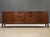 A mid century modern walnut long sideboard credenza designed by Jens Risom with sculpted black drawer pulls and cabinet...
