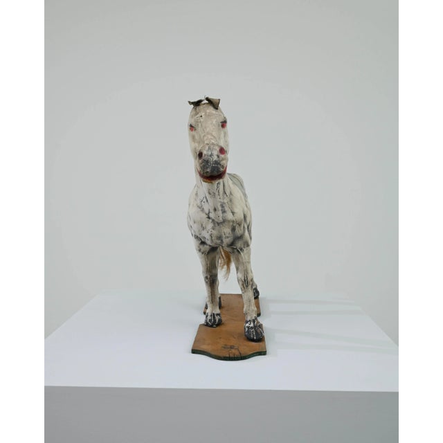 A wooden decorative sculpture of a horse created in early 20th century France. Playfully painted, and caught mid-pose,...