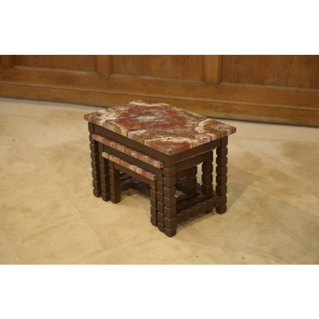 A stunning trio of nesting tables, typical of the brutalist aesthetic of the 1960s. The wooden structure is punctuated by...